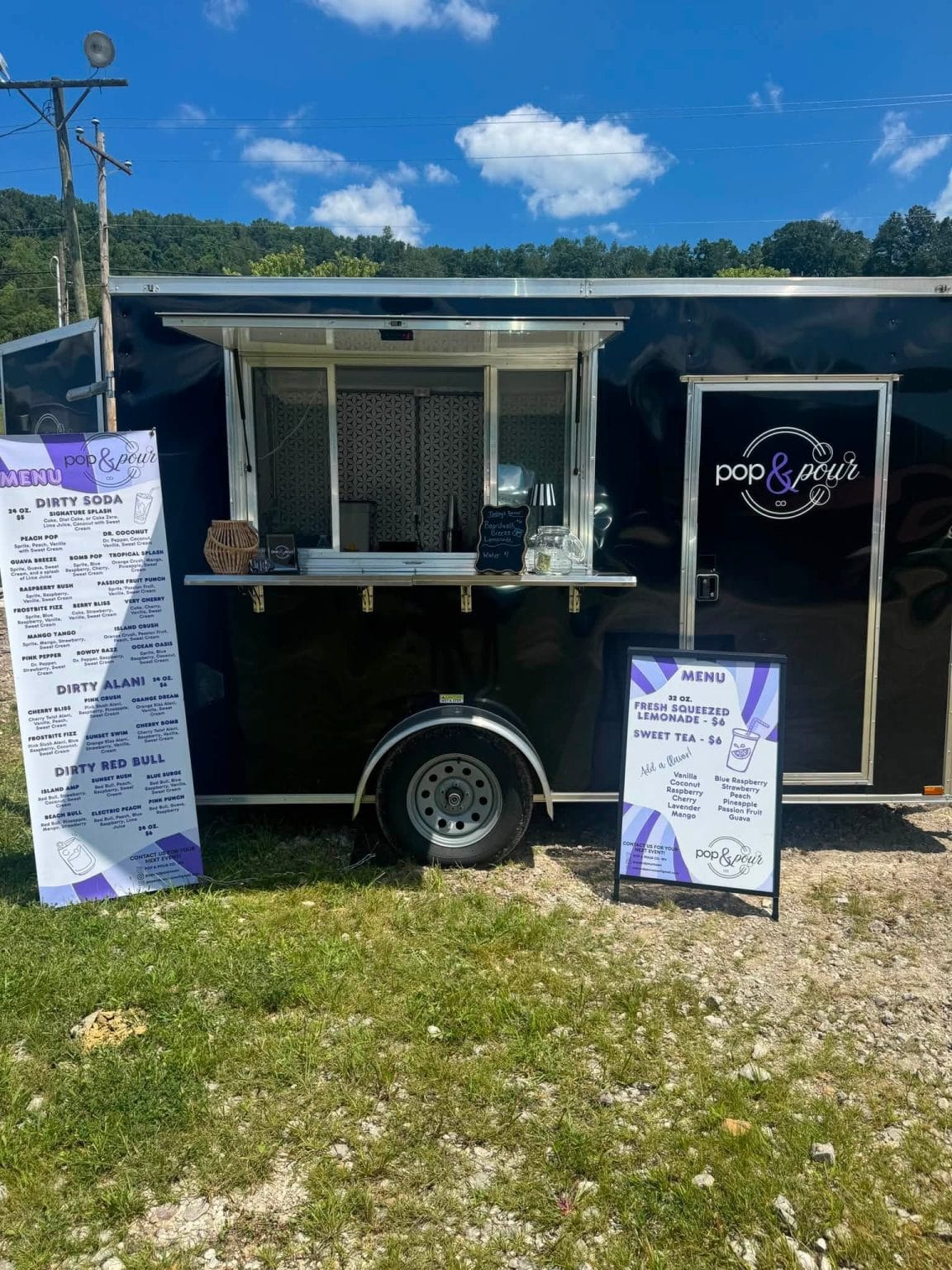 Pop & Pour Co. beverage trailer set up with drink menu displays at a West Virginia event